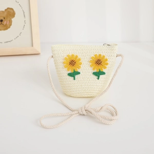 Dettaglio borsa a tracolla in paglia per bambini con ricamo a girasole e tracolla in corda