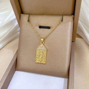 Close-up of golden Virgin Mary pendant necklace with sparkling zircons and cross detail