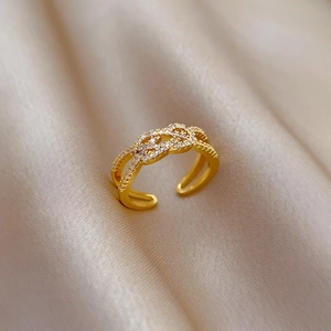 Gold plated criss-cross adjustable ring with micro-paved cubic zirconia on silk fabric