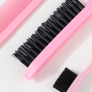 Macro detail of dense black bristles and smooth pink handles of hair styling brushes