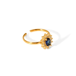 Detail of gold-plated open ring featuring a blue oval gemstone with a halo of zircons