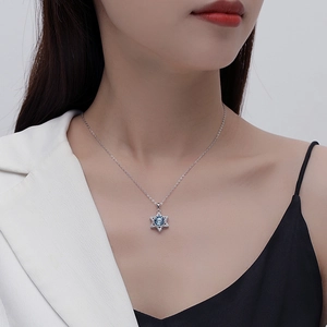 S925 sterling silver necklace with star pendant and blue crystal on a female model