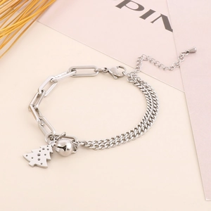 Detail of silver dual-chain bracelet with Christmas tree and bell charms on pink card