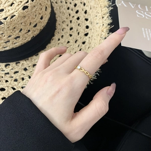 Detail of 18K gold plated chain ring with claw-set diamond on female finger