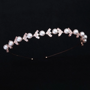 Rose gold headband with white pearls and sparkling cubic zirconia on a black background