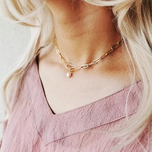 Close-up of double-layered gold paperclip chain and bead necklace with a baroque pearl