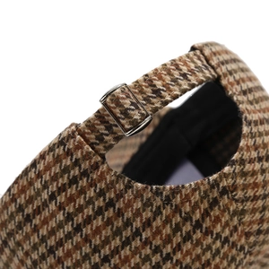 Detail of silver metal adjustment buckle on the houndstooth pattern baseball cap