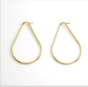 Macro shot of large polished gold teardrop earrings with secure clasp closure