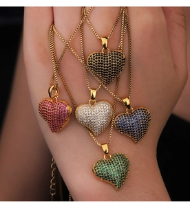 Detailed close-up of colorful heart pendants in black, red, blue, and green with cubic zirconia