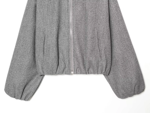 Close-up of grey wool-texture bomber jacket with metal zipper and side pockets