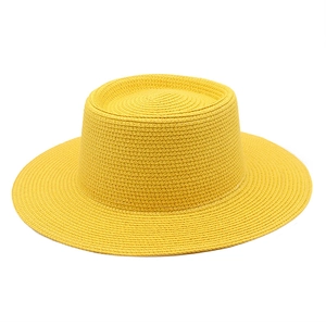 Detailed weave of a bright yellow straw boater hat with a flat top for summer sun protection