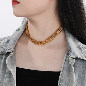 Close-up of golden braided fish-scale chain necklace on neck with 18k gold plating