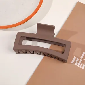 Detail of a large matte brown rectangular hair claw clip for thick hair styling