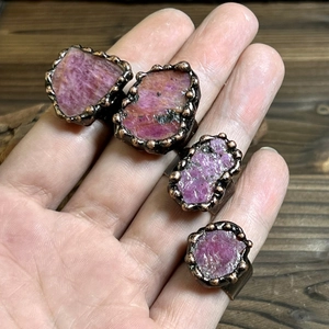 Vintage irregular red raw stone rings with antique bronze plating on dark wood