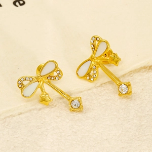 Elegant bow-shaped drop earrings with white enamel and star pendant in gold finish