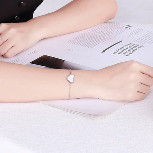 Detailaufnahme des herzförmigen Muschel-Anhängers am feinen Edelstahl-Silberarmband