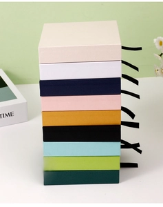 Vertical stack of drawer jewelry boxes with silk ribbons in various vibrant colors