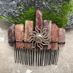 Detail of handmade hair comb with pink crystals, silver sun pendant and black metal teeth
