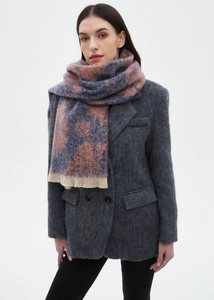 Close-up of blue and pink tie-dye scarf featuring textured knit and soft tassel edges