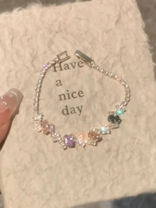 Detail of silver bangle with colorful oval gemstones and cubic zirconia clasp