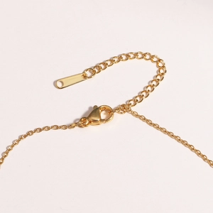 Detailed close-up of the golden lobster clasp and extension chain on the necklace