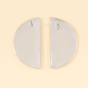 Macro detail of silver semi-circular earrings showing the metal posts and butterfly backs