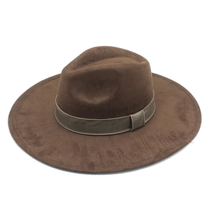 Detail view of a dark brown wide brim fedora hat with textured ribbon band on white background