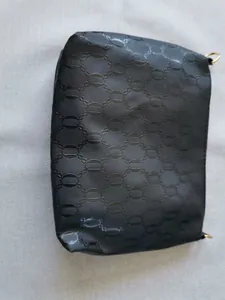 Top view of black textured clutch bag measuring 25cm with gold hardware and geometric pattern