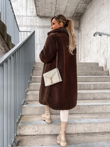 Detailed texture of thick dark brown teddy fleece material on long winter coat