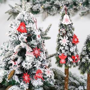 Wooden Christmas hanging ornaments set with red and white angels and deer on snowy tree