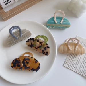 Eleganti mollette per capelli in acetato leopardato in vari colori su vassoio bianco