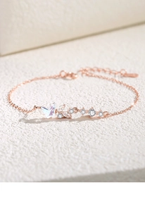 Vue détaillée d'un bracelet papillon en or rose serti de zircons étincelants et breloques