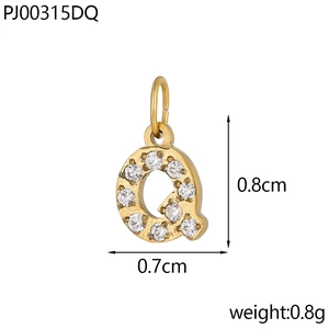 Macro detail of a gold letter Q pendant with dimensions 0.8cm by 0.7cm and sparkling zircon stones