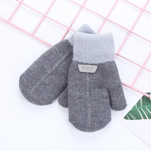 Detail of knit winter mittens showing two-tone grey design and fashion leather patch