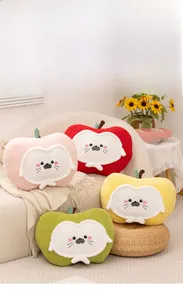 Detail of plush apple-shaped seal pillows with soft fleece texture in living room setting