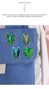 Detailed enamel tropical leaf pins set pinned on a canvas bag showing decorative use