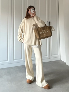 Women's cream knit set featuring a loose crewneck sweater and high-waisted wide-leg pants
