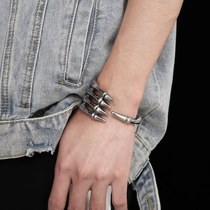Detailed close-up of a vintage skeleton claw open cuff bracelet in silver titanium steel