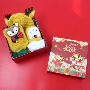 Detailed close-up of a festive children's knit hat and plush gloves in a gift box