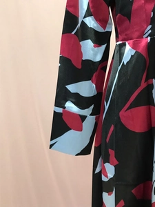 Close-up of floral print satin dress showing smooth fabric texture and draped waist detail