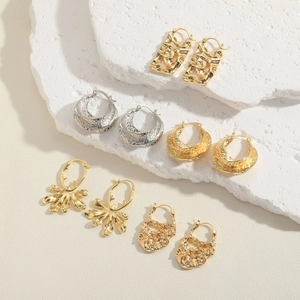 Set of five irregular geometric earrings in gold and silver finish on stone prop