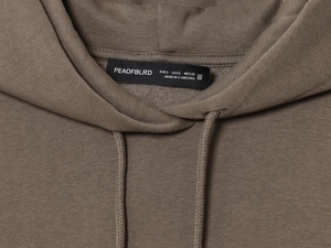 Close-up of brown hoodie collar showing cotton fabric texture and size label detail