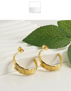 Detailed view of C-shaped 18k gold plated stainless steel earrings with ripple texture