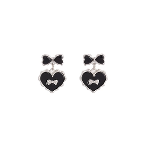 Gros plan de boucles d'oreilles gothiques avec motif de cœur noir et nœud