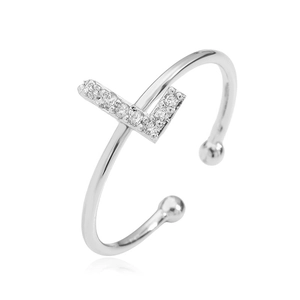Macro shot of silver V-shaped ring with pavé crystals and bead ends on white background