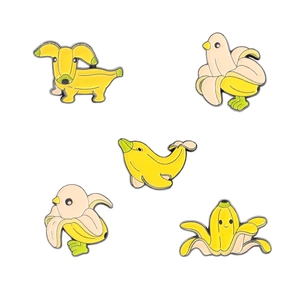 Set of five cute yellow banana-themed enamel pins featuring animal and creative designs