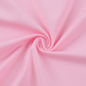 Close-up of pink ribbed knit fabric texture showing fine vertical threads and soft finish