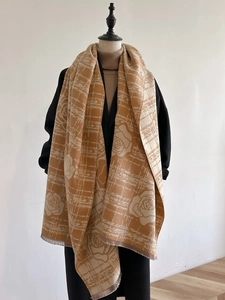 Elegant cashmere-like camel shawl with rose patterns and fringe, displayed on a mannequin