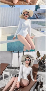 Detail shot of the ribbed texture and long sleeve design on this white one-piece swimsuit