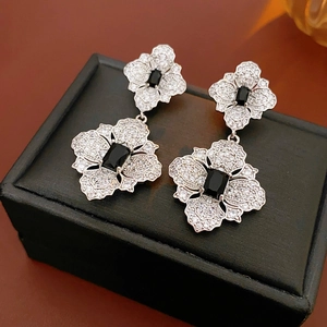 Detail of silver flower earrings with black crystal stone on black jewelry box